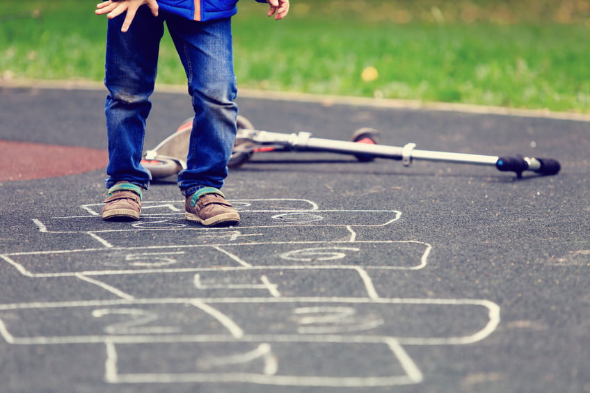 kid playing hopscotch on playground outdoors, children outdoor activities