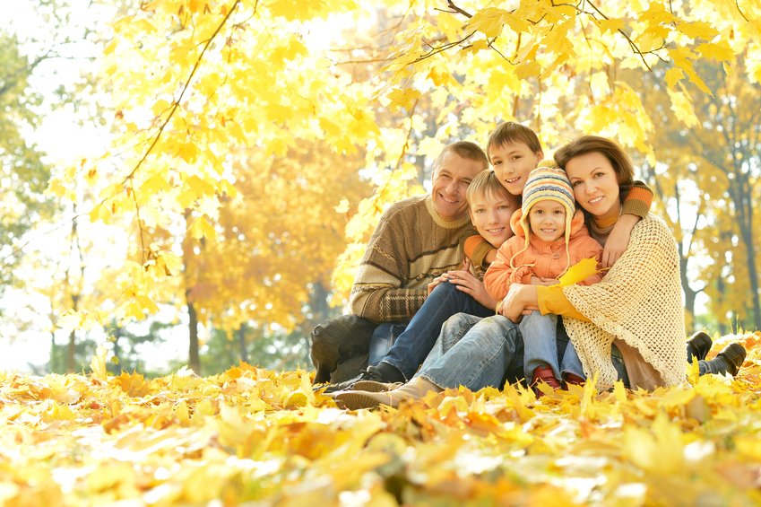 Happy smiling family relaxing in autumn forest