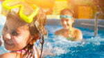 Children playing in pool. Two little girls having fun in the pool. Summer holidays and vacation concept