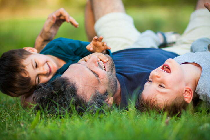 Father and two sons playing in the park.