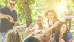 Happy friends having fun at barbecue party drinking beer, eating ,listening music - Young people enjoying bbq dinner outdoor - Friendship and summer concept - Warm filter - Focus on center blond guys