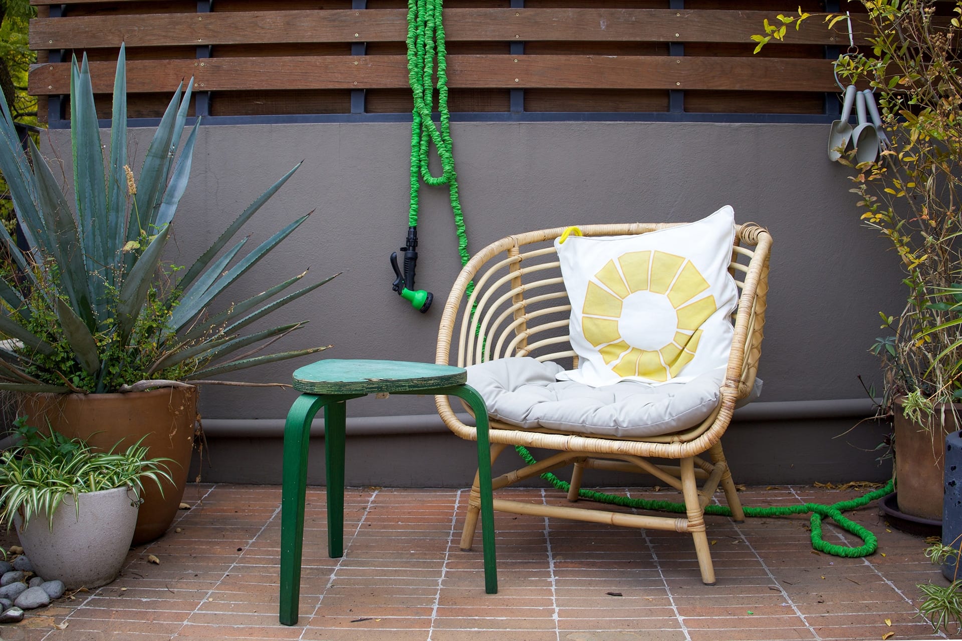 Wicker patio chair with decorative cushion — top 2026 outdoor furniture trend
