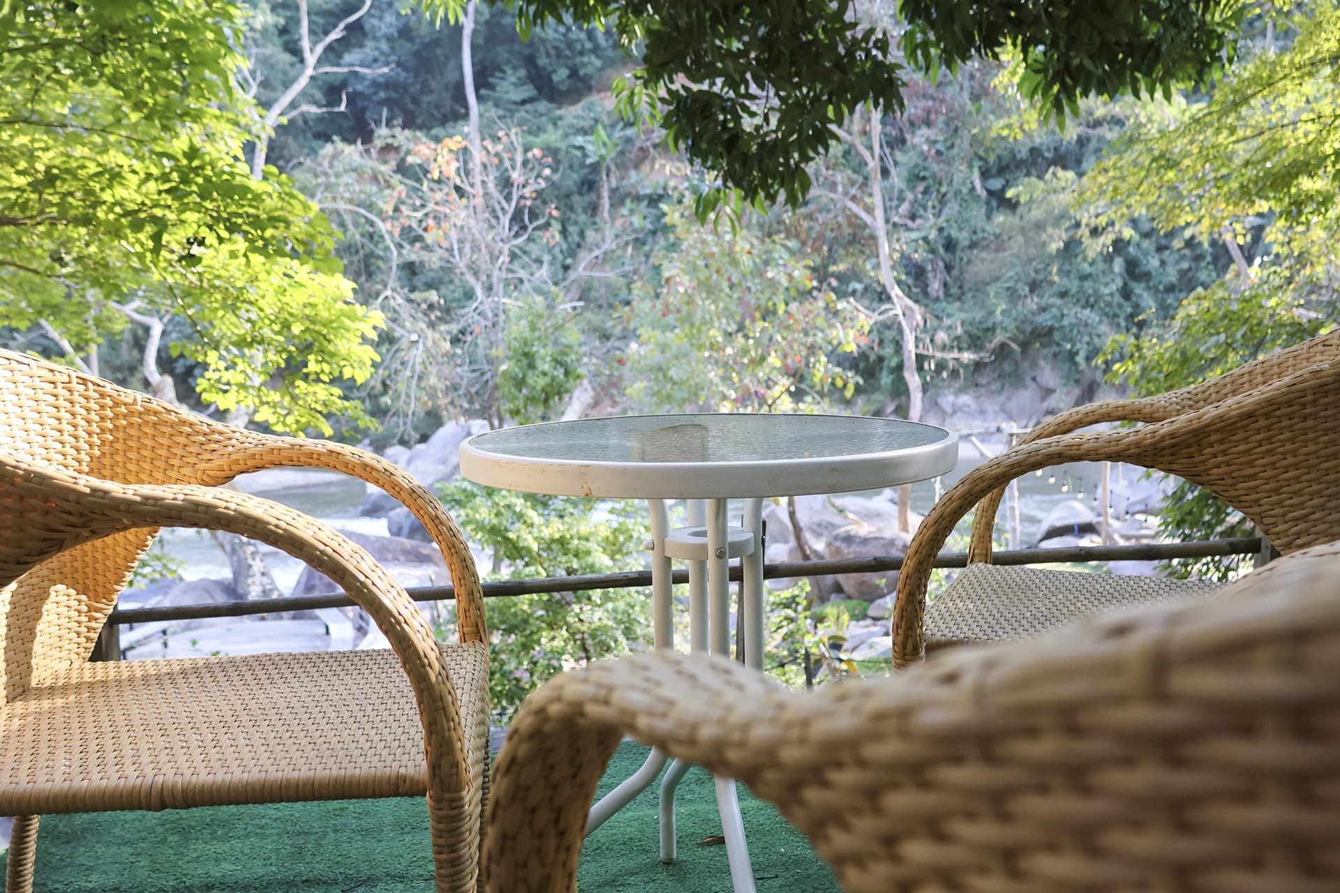 Wicker chair and glass table showcasing durable patio furniture materials