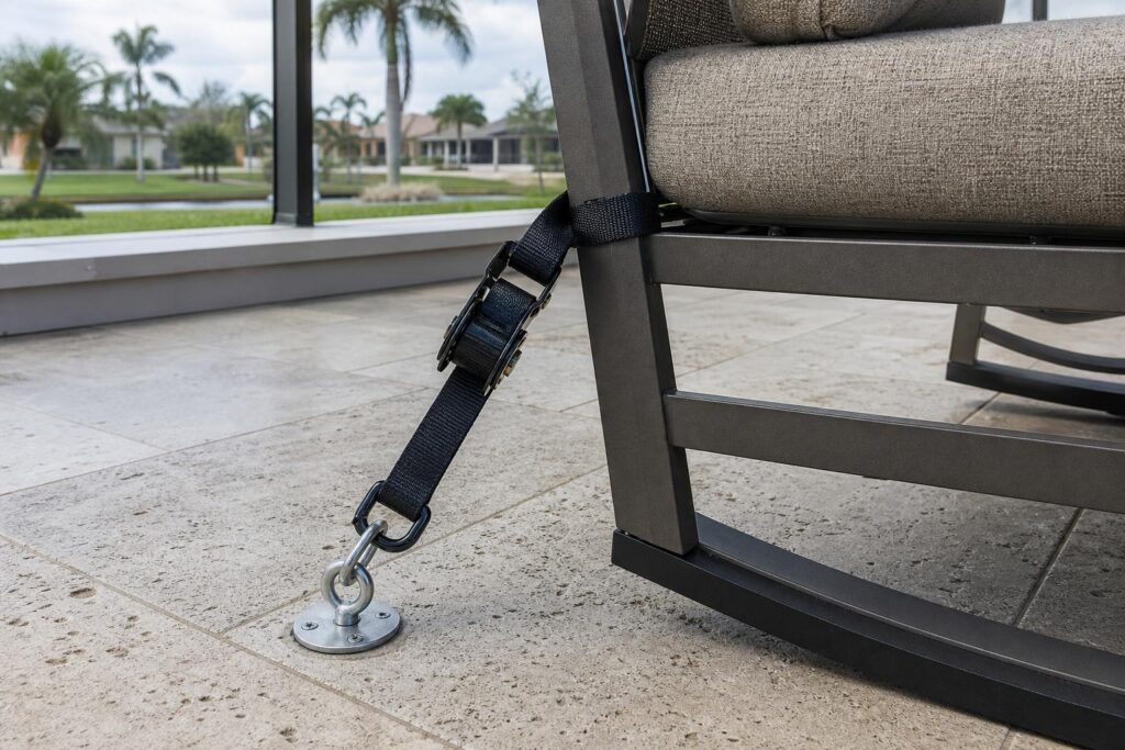 Ratchet strap and anchor securing an aluminum patio chair leg