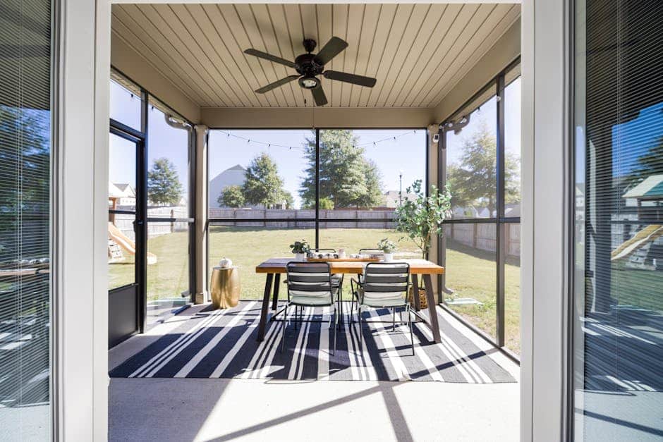 Overhead view of a screened Florida lanai with two outdoor rugs defining a dining area and a conversation area on concrete pavers