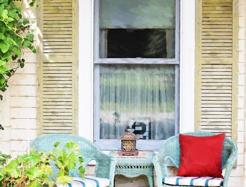 Powder-coated aluminum and resin wicker patio furniture arranged on a Florida lanai with tropical plants