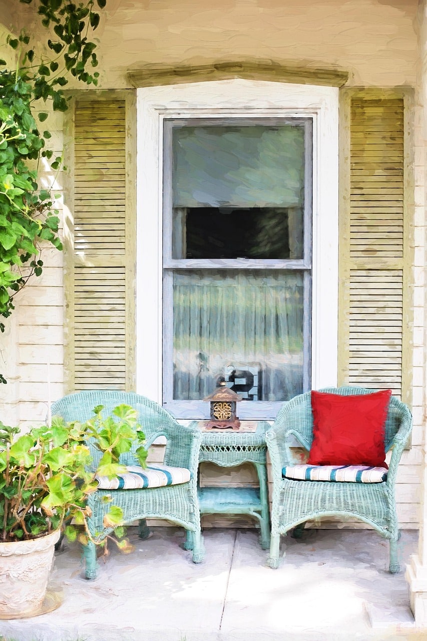 Tropical print Sunbrella cushions on outdoor wicker furniture surrounded by palm plants on a Florida patio