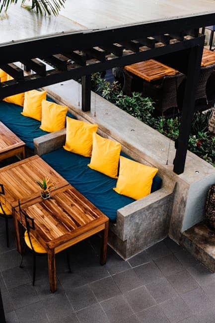 Well-scaled deep seating set with Sunbrella cushions arranged inside a spacious Florida pergola